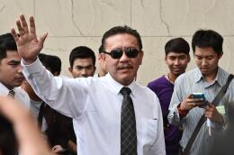 Thai massage parlour impresario turned politician Chuwit Kamolvisit (C) waves as he arrives for a hearing at a criminal court in Bangkok on October 15, 2015. Chuwit appeared in court on October 15 over accusations he and his associates demolished a group of bars in the heart of Bangkok’s nightlife in 2003. If found guilty Chuwit could face up to five years in jail. AFP PHOTO / Christophe ARCHAMBAULT (Photo by CHRISTOPHE ARCHAMBAULT / AFP)
