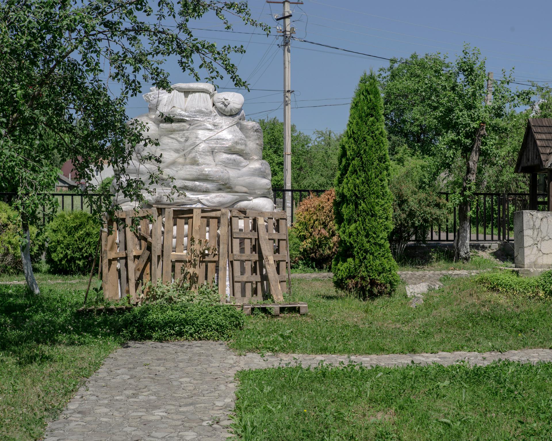 A côté de la maison familiale, la stèle de Stepan Bandera, rapportée de Munich, est protégée en cas de bombardement russe, à Stary Ouhryniv (Ukraine), le 25 juin 2022.