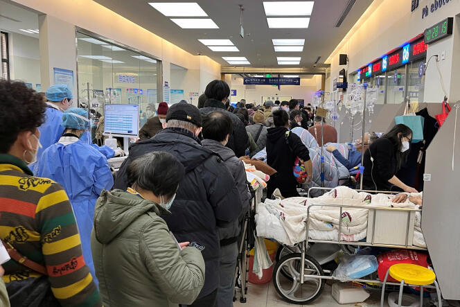 Les patients sont allongés sur des lits à côté de comptoirs fermés au service des urgences de l’hôpital de Zhongshan, à Shanghaï, en Chine, le 3 janvier 2023.
