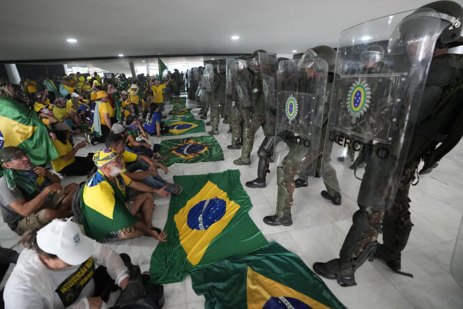 Alborotadores pro-Bolsonaro bajo vigilancia policial en el palacio presidencial de Planalto en Brasilia el 8 de enero de 2023.