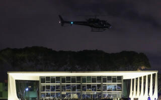 A Police helicopter flies over the Planalto Palace after it was stormed and vandalized by supporters of Brazil's former President Jair Bolsonaro in Brasilia, Brazil, Sunday, Jan. 8, 2023. Protesters who refuse to accept Bolsonaro´s election defeat stormed Congress, the Supreme Court and presidential palace in the capital, a week after the inauguration of his rival, President Luiz Inacio Lula da Silva. (AP Photo/Eraldo Peres)