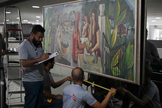 Des ouvriers prennent des mesures pour remplacer un miroir brisé où est accroché le tableau vandalisé « As Mulatas » du peintre Emiliano Di Cavalcanti, au palais du Planalto à Brasilia, le 9 janvier 2023.
