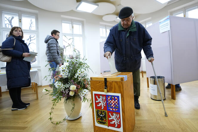 A voter slips his ballot into the ballot box at a polling station in Pruhonice for the first round of the presidential election in the Czech Republic on January 13, 2023.