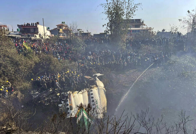Los rescatistas, observados por los residentes locales, intervinieron en el lugar del accidente de un avión de Yeti Airlines, ocurrido el 15 de enero de 2023 en Nepal y que causó la muerte de al menos 67 personas.