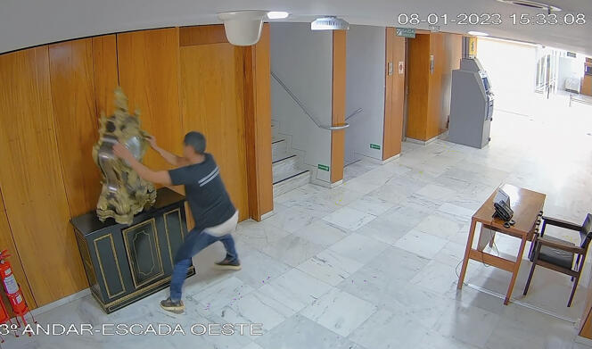 Image prise par une caméra de vidéosurveillance montrant un homme jetant une horloge au sol dans le palais présidentiel du Planalto, à Brasilia, le dimanche 8 janvier 2023.