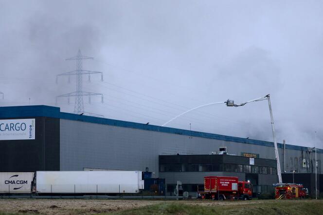 Firefighters water an industrial building of Bolloré Logistics, in Grand-Couronne, near Rouen, on January 17, 2023.