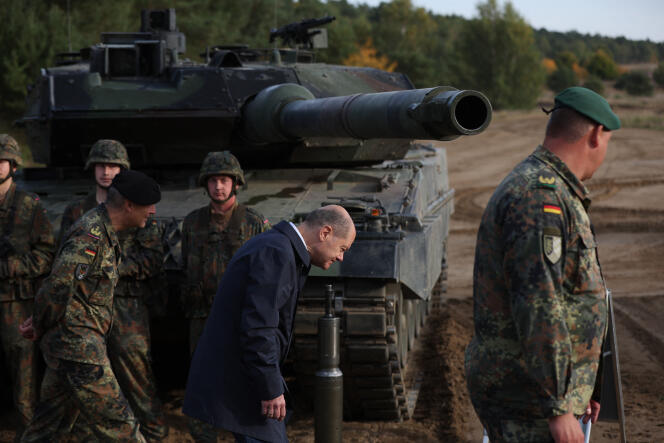 Le chancelier allemand, Olaf Scholz (au centre), devant un char de combat Leopard 2 des forces armées allemandes Bundeswehr, lors d’une visite pendant un exercice d’entraînement sur le terrain militaire d’Ostenholz, dans le nord de l’Allemagne, le 17 octobre 2022. 