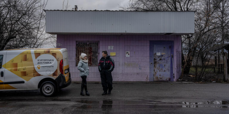 Lina, postière, et Serhii, chauffeur, attendent d'avoir des nouvelles de leurws clients, qu'ils appèlent par téléphone à l'arrivée dans un village, à Zahaltsi, en Ukraine, le 5 janvier 2023. ADRIENNE SURPRENANT / MYOP POUR « LE MONDE »