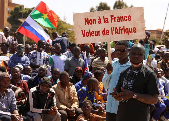 People hold a sign as they gather to show their support to Burkina Faso's new military leader Ibrahim Traoré and demand the departure of the French ambassador at the Place de la Nation in Ouagadougou, Burkina Faso January 20, 2023. The sign reads 