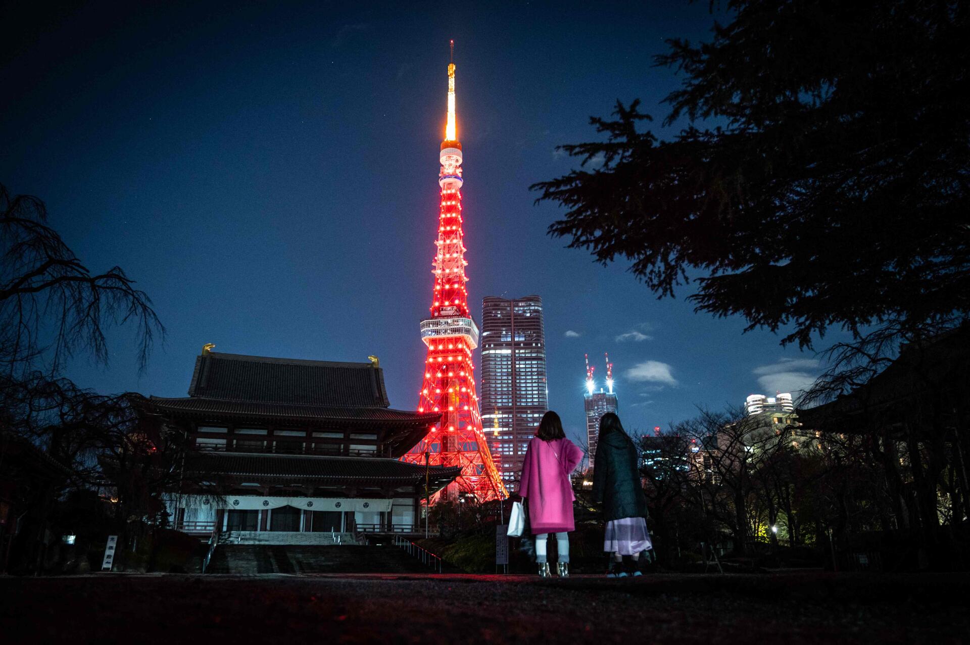 Frente al templo Zojo-ji, mientras la Torre de Tokio se ilumina en rojo para celebrar el Año Nuevo chino, en Tokio el 21 de enero de 2023. 
