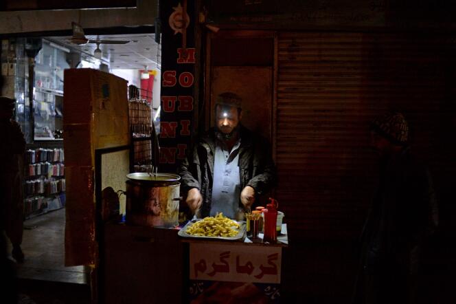 Un comerciante fríe papas en su puesto del mercado durante un corte de energía en todo el país, en Islamabad el 23 de enero de 2023.