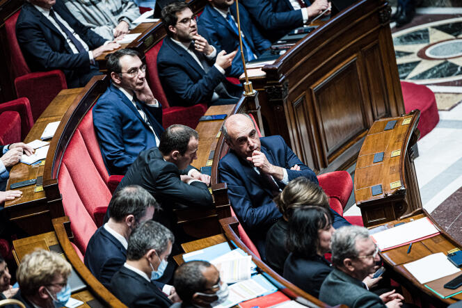 El diputado de LR Fabien Di Filippo conversa con el presidente del grupo LR, Olivier Marleix, no lejos del Ministro del Interior, Gérald Darmanin, durante una sesión de preguntas al gobierno, en la Asamblea Nacional, el 10 de enero de 2023. 