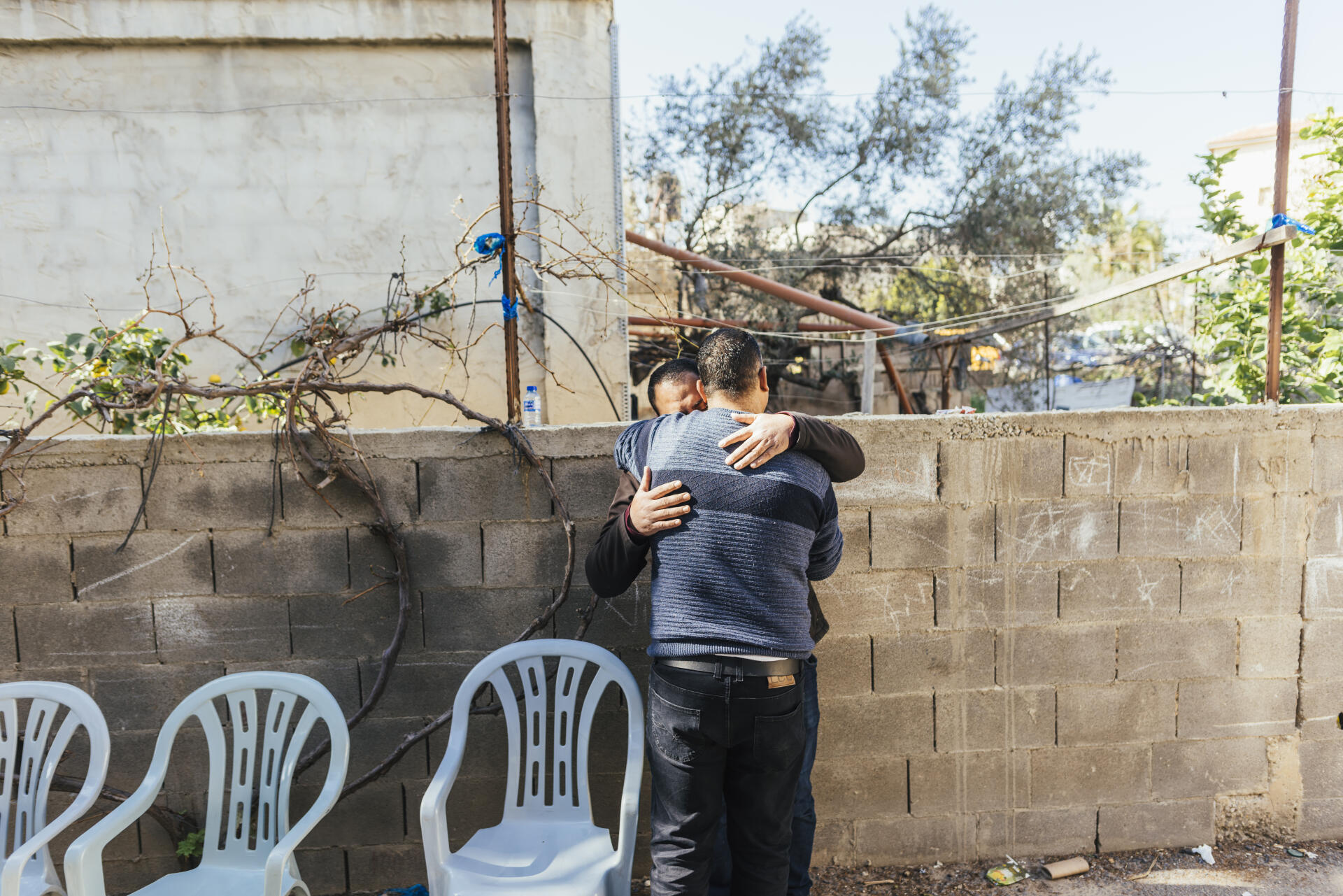 Dhafer Ataya, adjoint au maire de Kafr Nameh (Cisjordanie), embrasse le frère de Tareq Maali le jour de la mort de ce dernier, devant la maison familiale, le 21 janvier 2023. 
