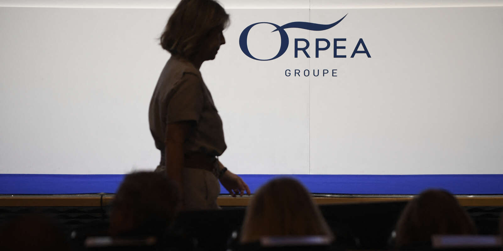 Une femme passe devant le logo d’Orpea lors de l’assemblée générale du grand opérateur français de maisons de retraite, à Paris, le 28 juillet 2022.
