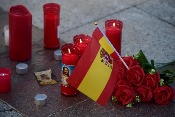 Une photo prise le 26 janvier 2023 à Algésiras, dans le sud de l’Espagne, montre le drapeau espagnol, des fleurs et des bougies sur la place près de l’église où un homme a été tué la veille.