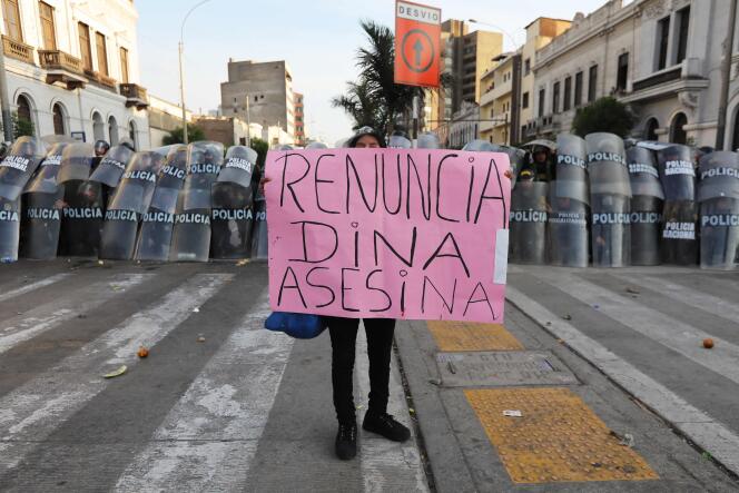 Una mujer sostiene un cartel con el lema 
