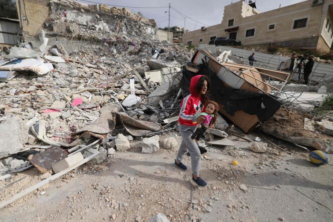 Une fillette palestinienne récupère sa poupée dans les décombres d’une maison détruite par des bulldozers israéliens à Jérusalem-Est, le 29 janvier 2023