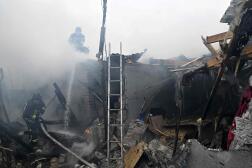 Des pompiers ukrainiens éteignent un incendie dans une maison à la suite d’un bombardement russe dans la ville de Kherson, le 29 janvier 2023, 