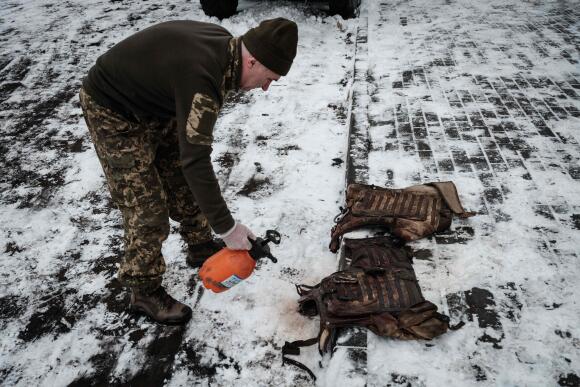 Un ambulancier nettoie les taches de sang sur les gilets pare-balles de militaires ukrainiens blessés, dans la région de Donetsk, le 29 janvier 2023.