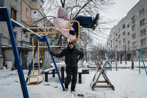 Un homme avec sa fille, après avoir quitté le sous-sol de leur immeuble pour prendre l’air, à Lyman, dans la région de Donetsk, le 29 janvier 2023.