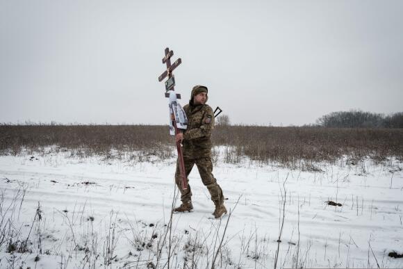 Oleksiy Storozh, 28 ans, porte une croix qui sera déposée sur la tombe de son meilleur ami, dans un cimetière de Sloviansk, le 30 janvier 2023.