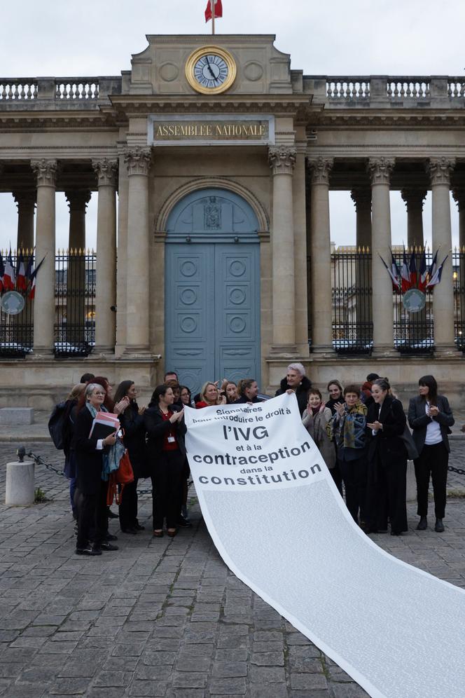 Diputados de La France insoumise y miembros de asociaciones abortistas despliegan una pancarta tras la votación de la Asamblea Nacional para añadir el derecho al aborto en la Constitución, frente al Palais-Bourbon, el 24 de noviembre de 2022.