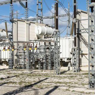 BAIXAS, FRANCE. JANVIER 2023.
L'Interconnexion électrique France-Espagne, connue aussi sous son nom de projet INELFE (acronyme pour INterconnexion ELectrique France-Espagne), est une ligne à courant continu à haute tension reliant le poste électrique de Baixas en France à celui de Santa Llogaia en Espagne. La liaison est réalisée à l'aide de deux câbles électriques en parallèle de tension ±320 kV, d'une longueur d'environ 65 km. 
En raison de ses caractéristiques techniques et pour réduire les pertes électriques dues au transport souterrain, l’interconnexion Baixas-Santa Llogaia fonctionne sous courant continu, au lieu du courant alternatif utilisé classiquement sur les autres réseaux. Cela suppose l’installation d’un dispositif de conversion du courant électrique à chaque extrémité de la ligne. C’est pourquoi il a été nécessaire de construire une station de conversion à Baixas et à Santa Llogaia. Ici celle de Baixas. 

L’interconnexion permet d’échanger 2800 mega watts ce qui correspond à la consommation de 2,8 millions de foyers ou la production de deux réacteurs nucléaires. 
Ce projet a trois fonctions principales:
- sécuriser l’alimentation entre les pays
- aider la transition énergétique en recherchant les énergies les plus decarbonnées en Europe (si pas de vent en Allemagne et soleil en Espagne ou au contraire) 
- faire profiter des meilleurs prix à tous les européens.