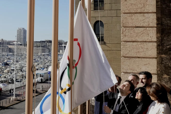 Le maire de Marseille, Benoît Payan (à gauche du groupe), hisse le drapeau olympique, au côté de Tony Estanguet (à droite), président du comité d’organisation des Jeux olympiques de Paris 2024, à Marseille, le 3 février 2023. 