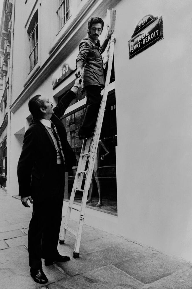 Paco Rabanne fixe l’enseigne de sa boutique, dans le 6e arrondissement de Paris, , le 26 octobre 1971.