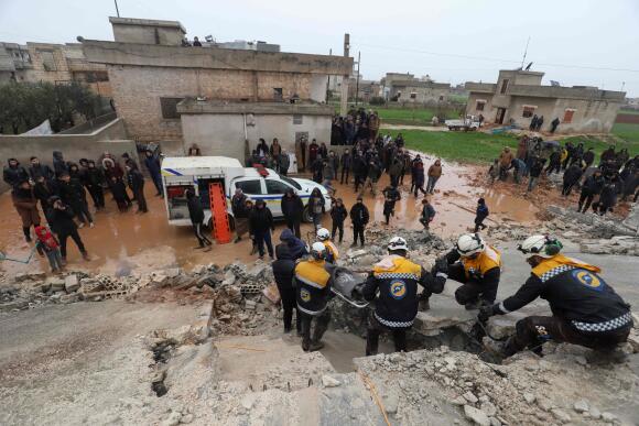 Des membres de la protection civile syrienne transportent une victime extraite des décombres, dans la campagne de la province d’Idlib, dans le nord-ouest de la Syrie, le 6 février 2023.
