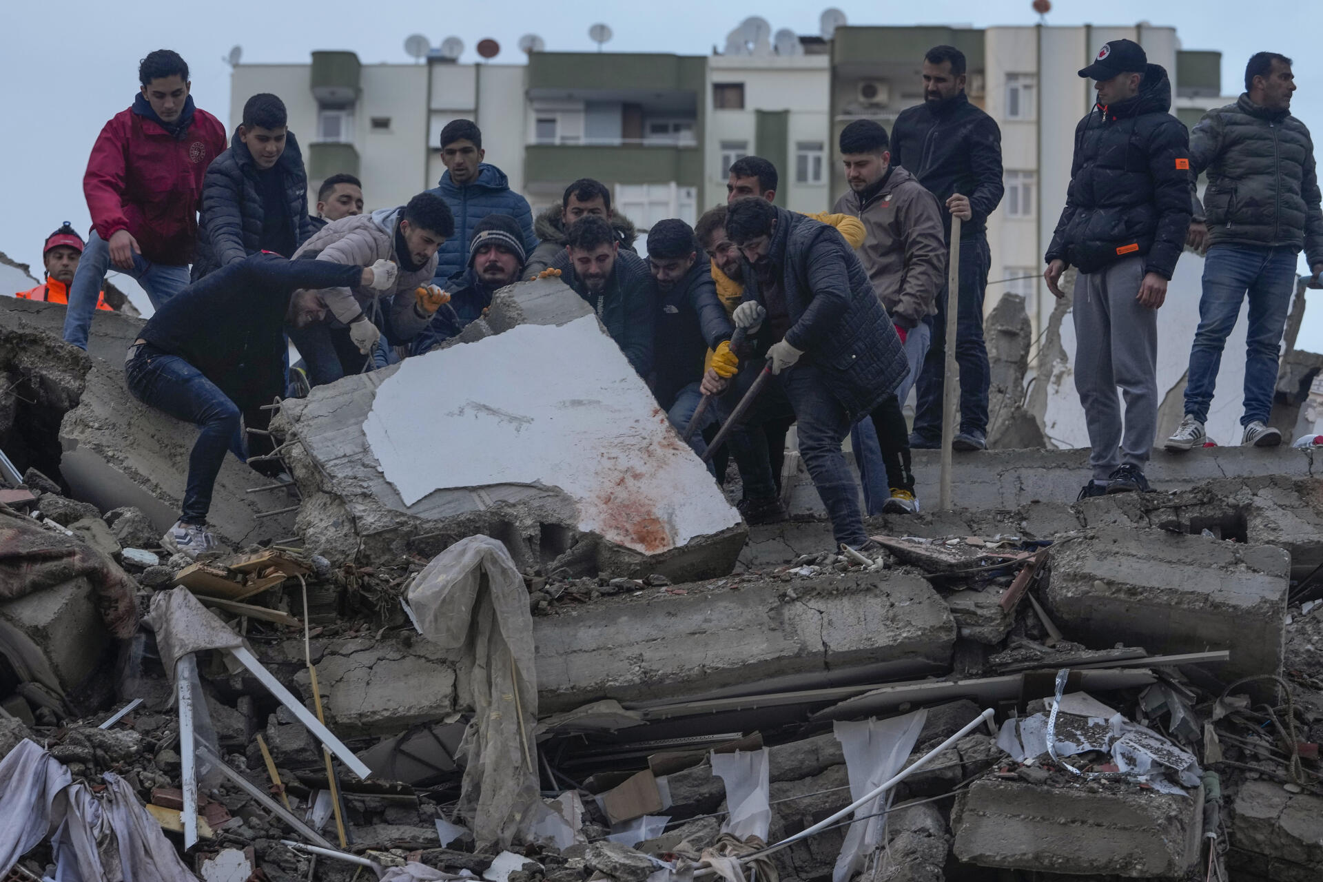 Des civils cherchent des personnes parmi les débris d’un bâtiment détruit à Adana, en Turquie, lundi 6 février 2023.