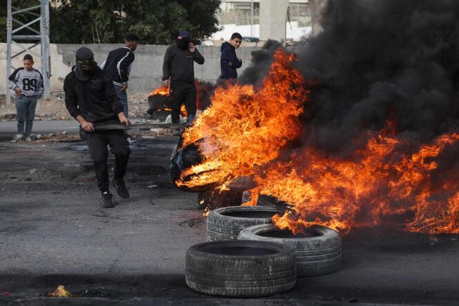 Des manifestants palestiniens brûlent des pneus pour bloquer une route menant à Jéricho, en Cisjordanie, le 6 février 2023, après un raid des forces israéliennes dans le camp de réfugiés d’Aqabat Jabr, situé à trois kilomètres au sud de la ville.
