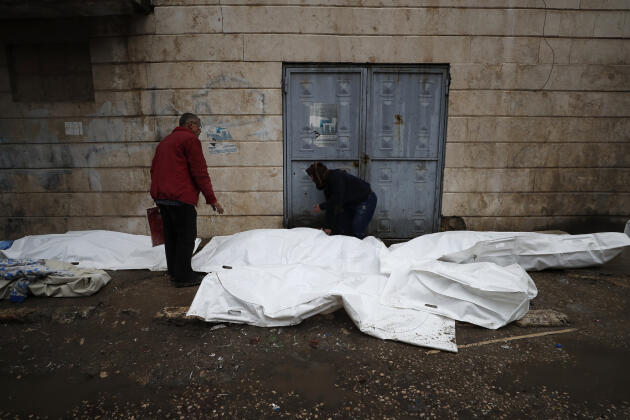 Hombres intentan identificar los cuerpos de las víctimas del terremoto afuera de un hospital en Alepo, Siria, el lunes 6 de febrero de 2023.
