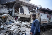 A resident stands in front of a collapsed building in Jandairis, in the countryside of Afrin, northwestern Syria, February 6, 2023.
