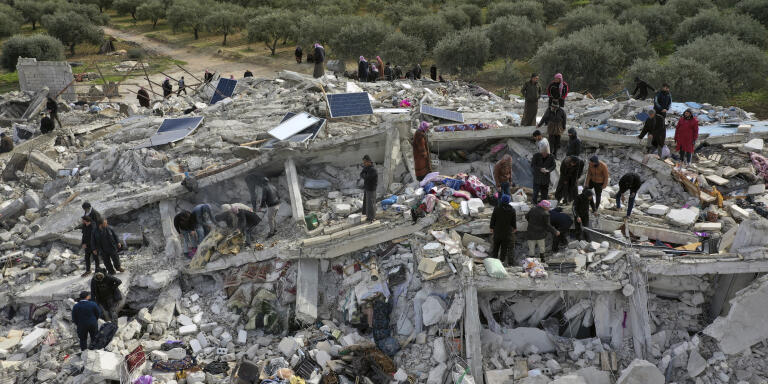 Civil defense workers and residents search through the rubble of collapsed buildings in the town of Harem near the Turkish border, Idlib province, Syria, Monday, Feb. 6, 2023. A powerful earthquake has caused significant damage in southeast Turkey and Syria and many casualties are feared. Damage was reported across several Turkish provinces, and rescue teams were being sent from around the country. (AP Photo/Ghaith Alsayed)