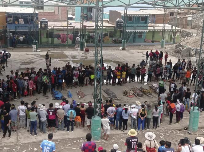 Residents stand around the bodies of persons who perished in recent landslides in Camana, Peru, Monday, February 6, 2023. 
