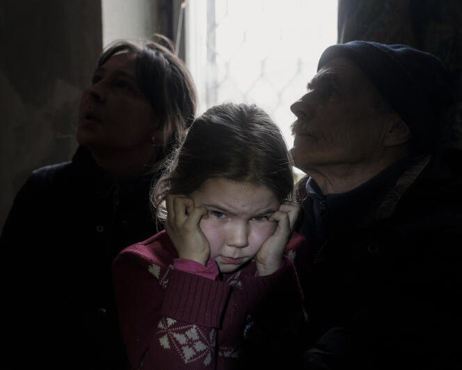 Aryna, 7, between her grandparents before her evacuation from Bakhmout on January 30, 2023, with her great-grandmother, by a group of special police forces called the White Angels.