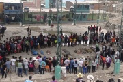 Residents stand around the bodies of persons who perished in recent landslides in Camana, Peru, Monday, February 6, 2023. 