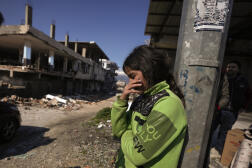 Une fille se tient à côté de bâtiments détruits à Antakya, dans le sud de la Turquie, le 8 février 2023.