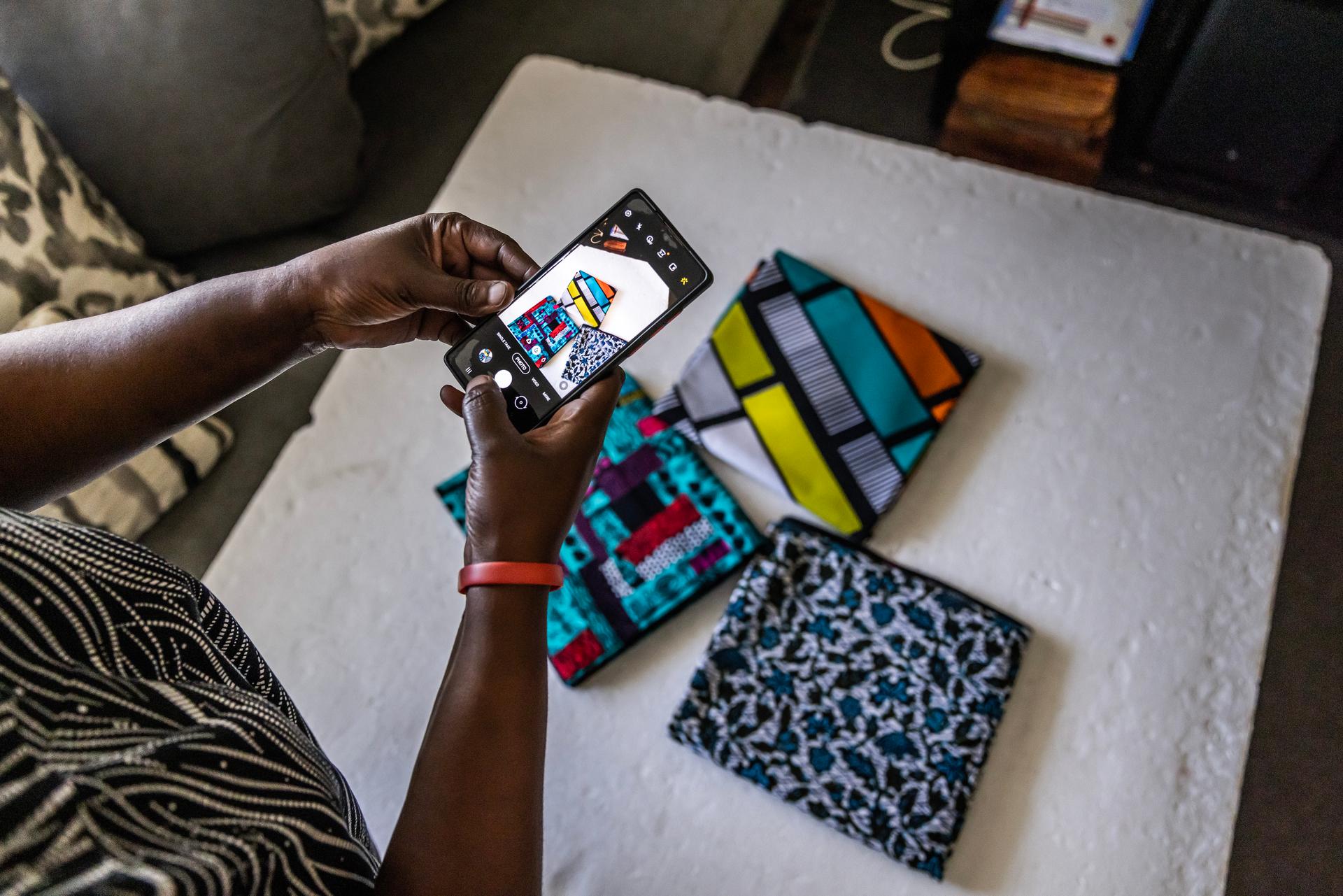 Juliana Busera prend des photos du Kitenge - morceau de tissu africain traditionnel - qu’elle vend pour les publier sur les pages commerciales des médias sociaux, chez elle à Kilimani, Nairobi, Kenya, le 17 janvier 2023.