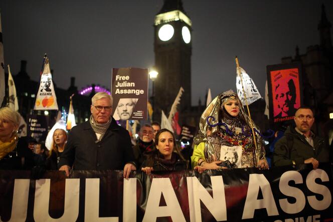 Stella Assange (center), wife of WikiLeaks founder Julian Assange, holds a banner as she walks with supporters of his during a 'Night Carnival for Assange' march in London on February 11, 2023. 