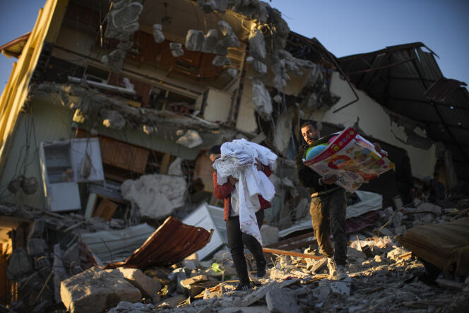 Des habitants retirent les affaires de leur maison détruite après le tremblement de terre, à Samandag, dans le sud de la Turquie, le 16 février 2023.