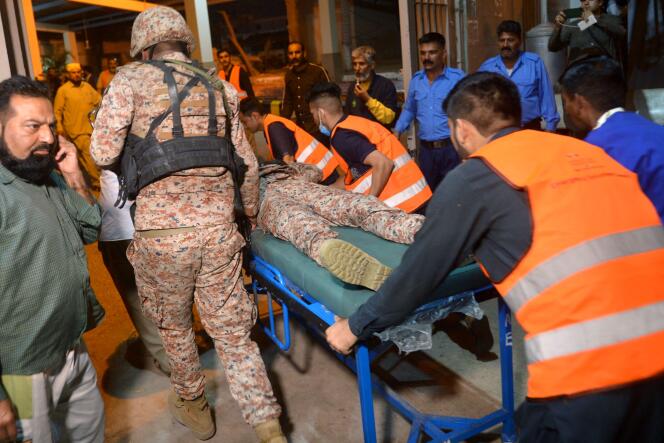 Los voluntarios llevan a un soldado herido a un hospital después de un ataque a un recinto policial en Karachi el 17 de febrero de 2023.