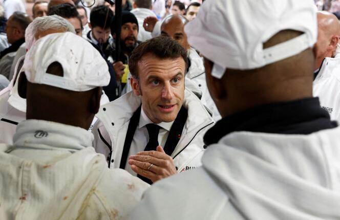  Emmanuel Macron discute avec un ouvrier lors d’une visite au Marché international de Rungis, le 21 février 2023. 