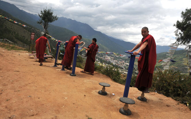 Des moines bouddhistes utilisent des équipements de sport sur le bord d’une route surplombant Thimphou, la capitale du Bhoutan, le 16 juin 2015.  
