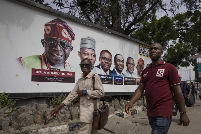 Pedestrians walk past campaign posters of All Progressives Congress (APC) candidate Bola Tinubu, Thursday, Feb. 23, 2023, in Lagos, Nigeria. 