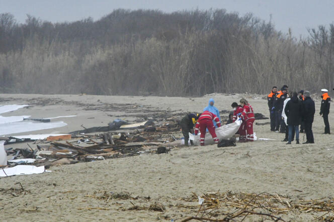 Los equipos de rescate cubren el cuerpo de un migrante que murió en el hundimiento de un bote que mató al menos a 59 personas, en una playa cerca de Cutro, en el sur de Italia, el domingo 26 de febrero de 2023.