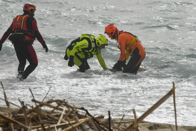 Des sauveteurs sortent un corps de l’eau, près de la plage de Cutro (dans le sud de l’Italie), à la suite du naufrage d’une embarcation qui transportait plus d’une centaine de migrants, le 26 février 2023. 