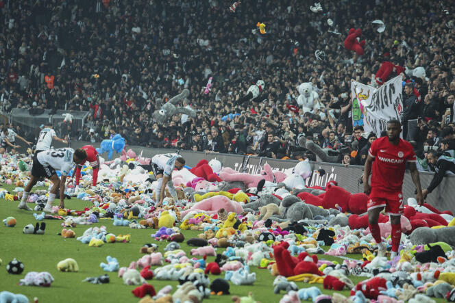 Los aficionados arrojan juguetes a la cancha durante el partido de fútbol de la Superliga turca entre Besiktas y Antalyaspor en el Estadio Vodafone en Estambul, Turquía, el domingo 26 de febrero de 2023. 