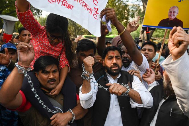 Des membres de l’Aam Aadmi Party manifestent contre l’arrestation du ministre en chef adjoint de Delhi, Manish Sisodia (représenté sur le panneau jaune), à New Delhi, le 27 février 2023. 